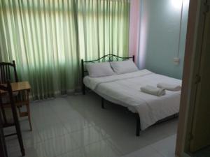 een slaapkamer met een bed met witte lakens en kussens bij OK.home@Donmuang airport in Bangkok