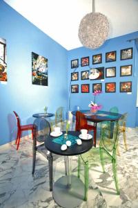 uma sala com mesas e cadeiras e uma parede azul em Villa Quaranta em Portici