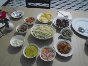 a table topped with bowls of different types of food at El Shaddai in Mannar