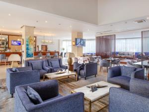 a large living room with blue chairs and tables at Golden Tulip Canaan Kampala in Kampala