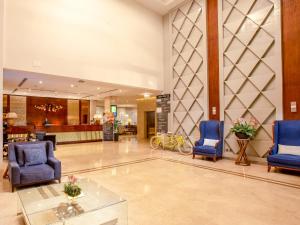 a lobby with two blue chairs and a waiting room at Golden Tulip Canaan Kampala in Kampala