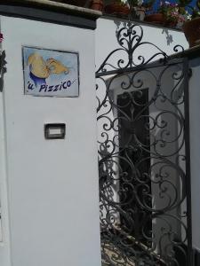 a white door with a sign on it next to a fence at U' Pizzico ( the pinch ) in Capri