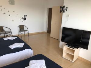 a bedroom with a bed and a flat screen tv at Autentic Boutikue in Costinesti