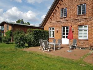 a table and chairs in front of a brick house at Ferienwohnung Techin am Schaalsee in Techin