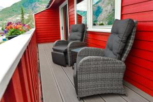 three wicker chairs and a table on a porch at Ingrids Apartments in Eidfjord