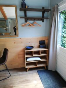 a room with a mirror and a chair and a shelf at Casa Batavia B&B in Lelystad