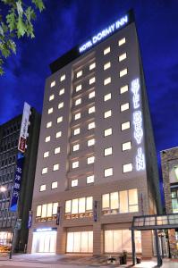 un bâtiment avec un panneau sur son côté dans l'établissement Dormy Inn Obihiro, à Obihiro