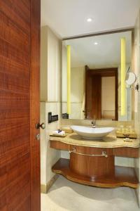 a bathroom with a sink and a large mirror at Seven Seas Hotel in New Delhi