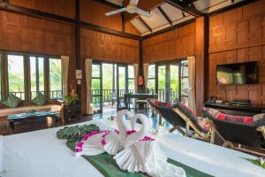 zwei Schwäne sitzen auf einem Tisch in einem Zimmer in der Unterkunft ThaiLife Wellness & Meditation Resort- SHA Plus in Khao Lak