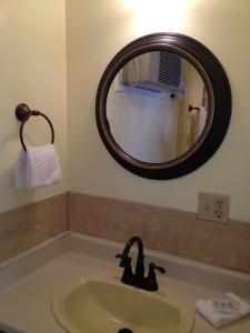 a bathroom with a sink and a mirror at Victorian Inn in Reno