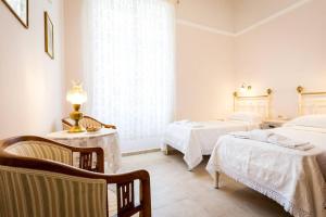 sypialnia z dwoma łóżkami, stołem i krzesłami w obiekcie Neoclassical flat with 2 bedrooms in Piraeus w Pireusie