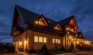 a large house with a gambrel roof at night at Penzion Palusak in Stará Lesná