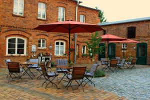 a group of chairs and tables with umbrellas in front of a building at Spree Chalet - adults only in Lübbenau