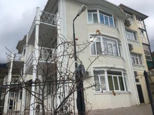 a white building with a street light in front of it at Private house villa Svetlana с сауной и бассейном in Yalta