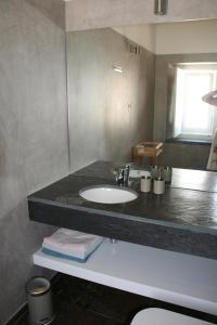 a bathroom with a sink and a black counter top at Casa do Sobreiro-Quinta do Briando in Portalegre