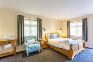 a bedroom with a bed and a chair and window at The Royal Oak in Loughborough