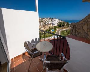 a balcony with a table and chairs and the ocean at Hostal Casa Mercedes in Nerja