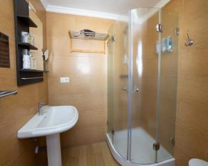 a bathroom with a glass shower and a sink at Hostal Casa Mercedes in Nerja
