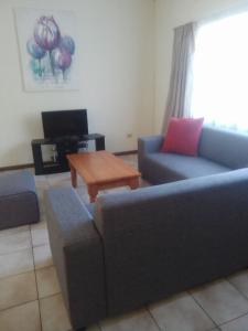 a living room with two couches and a coffee table at Doonside Holiday Apartments in Amanzimtoti