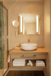 a bathroom with a tub, sink and mirror at Hotel Le B d'Arcachon in Arcachon
