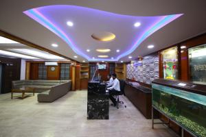 a woman sitting at a desk in a hotel lobby at Hotel Chetan International in Bangalore