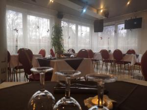 uma sala de jantar com mesas, cadeiras e janelas em Hotel BEST with FREE PARKING em Riga