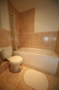 a bathroom with a toilet and a bath tub and a toilet at Chaucer Apartment in Keswick