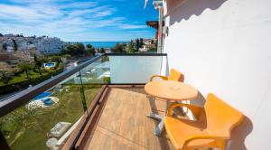 a balcony with a table and chairs and a view at Hostal Casa Mercedes in Nerja
