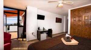 a living room with a couch and a tv and a door at Hostal Casa Mercedes in Nerja