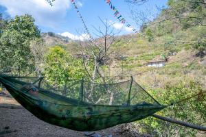 a person is sleeping in a hammock at TRIBE AQUA a nature retreat above Neer waterfall in Rishīkesh