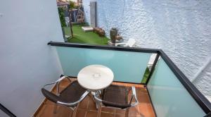 a white chair sitting on top of a balcony at Hostal Casa Mercedes in Nerja