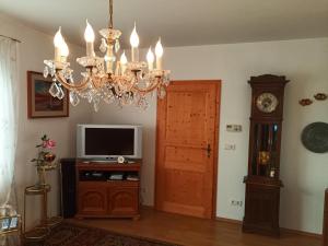 a living room with a chandelier and a tv at Ferienwohnung Waldblick im Haus Ludwig in Masserberg