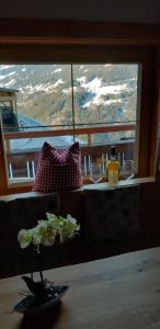 a vase with flowers on a table in front of a window at Rossruckhof in Rohrberg