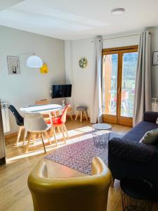 ein Wohnzimmer mit einer Couch und einem Tisch in der Unterkunft Apartamentos Maladeta in Benasque