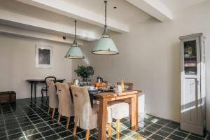 a dining room with a wooden table and chairs at De Verwennerie in Zierikzee