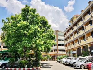 a tree in a parking lot next to a building at Paholyothin Park Place in Bangkok