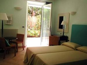 a bedroom with a bed and a door to a patio at Locanda Conchiglia D'Oro in Varigotti