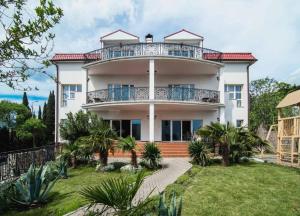 a large white house with a balcony at Villa Oneiro in Alupka