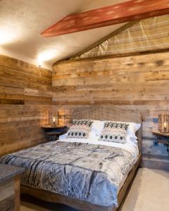 1 dormitorio con 1 cama en una pared de madera en The Potting Shed Maidstone en Langley