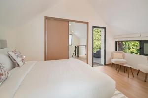 a bedroom with a large white bed and a desk at Oscar's House by An Island Apart in Ponta do Sol
