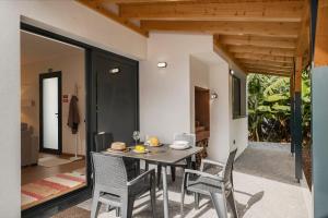 uma sala de jantar com mesa e cadeiras em Oscar's House by An Island Apart em Ponta do Sol