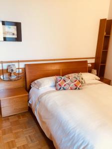 - un lit avec une tête de lit en bois dans une chambre dans l'établissement Delizioso appartamento in corte, à Vittuone