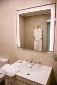 a bathroom with a white sink and a mirror at Foresta Festival Park in Prokhorovo