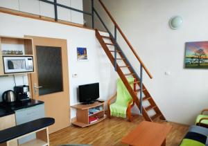 a living room with a staircase and a television at Šťastná třináctka in Svoboda nad Úpou