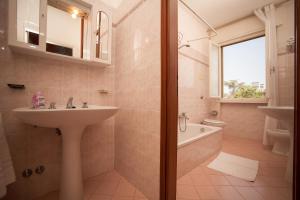 a bathroom with a sink and a toilet and a tub at Appartamenti & Bungalows Luca Angiolin in Cavallino-Treporti +87 photos