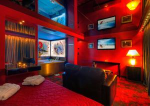 czerwony pokój z łóżkiem i wanną w obiekcie ALFA HOTEL w mieście Skaramangás