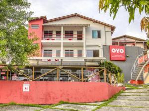 un edificio con una pared roja delante de él en OYO Praia Hotel Recanto do Tomé - Salvador, en Paripe