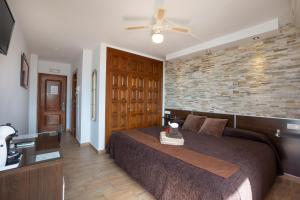 a bedroom with a bed and a brick wall at Hostal Casa Mercedes in Nerja