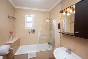 a bathroom with a bath tub and a sink at Hostal Casa Mercedes in Nerja