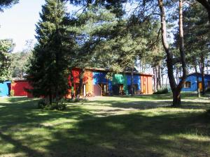 une maison dans une cour avec des arbres au premier plan dans l'établissement Fewoamglubigsee, à Wendisch Rietz